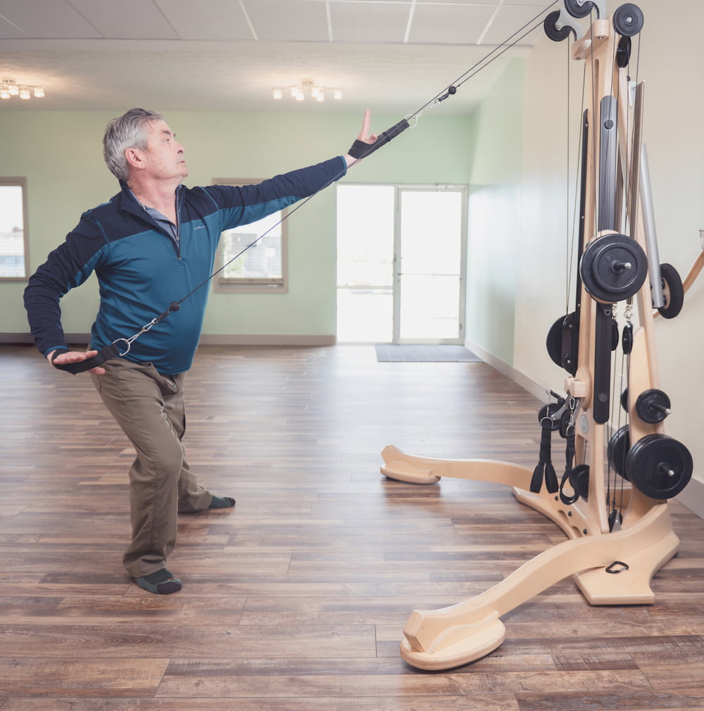 elderly man getting a full body workout on the gyrotonic machine