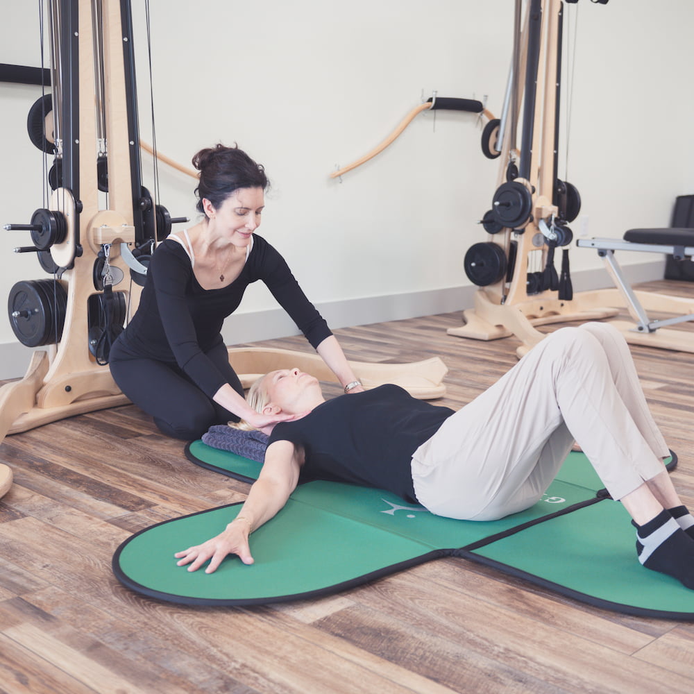the instructor work with a client on a floor mat